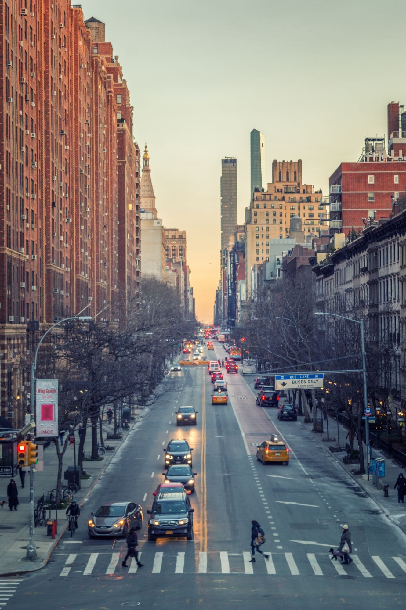 Avenue de New York vue d’en haut au coucher du soleil, immeubles de brique rouge, taxis jaunes et piétons sur un passage